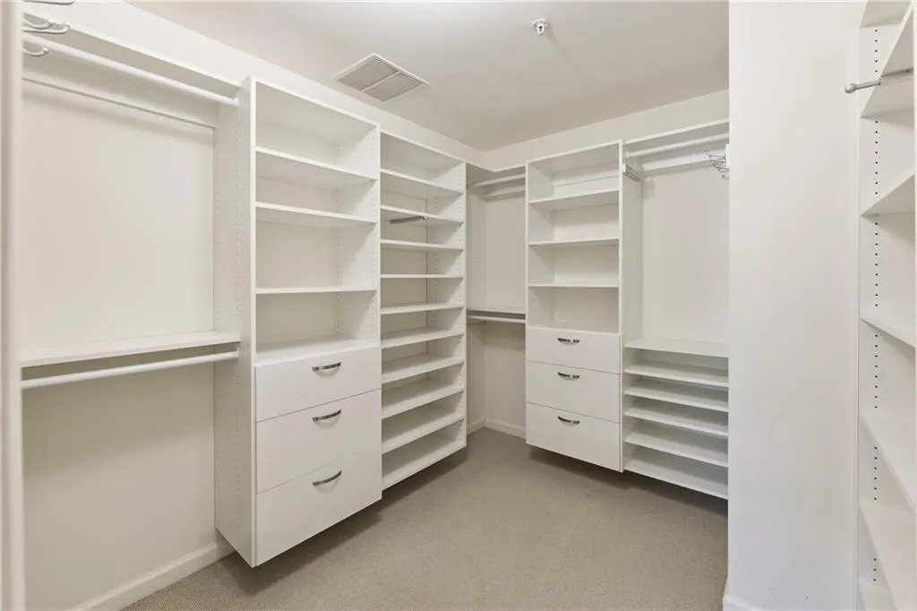 Fabulous, oversized closet with built-in shelving and drawers in primary.