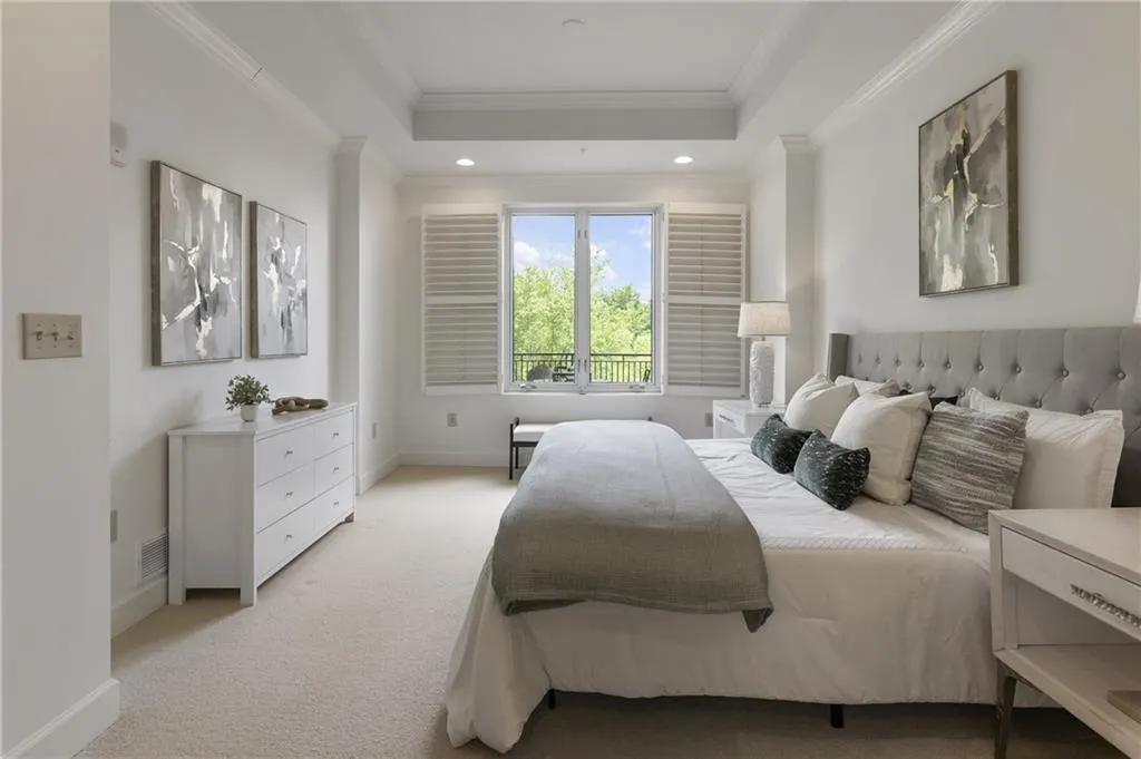 Soothing primary with trey ceilings, upgraded carpet and views to the terrace and trees beyond.