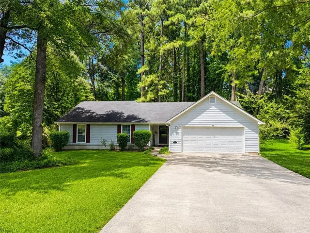 Ranch-style residence featuring light-colored siding and a dark shingle roof