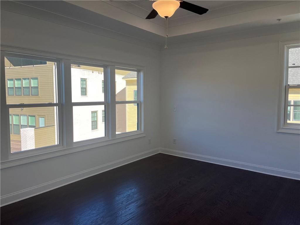 The primary suite features hardwood floors, can lighting and a ceiling fan.