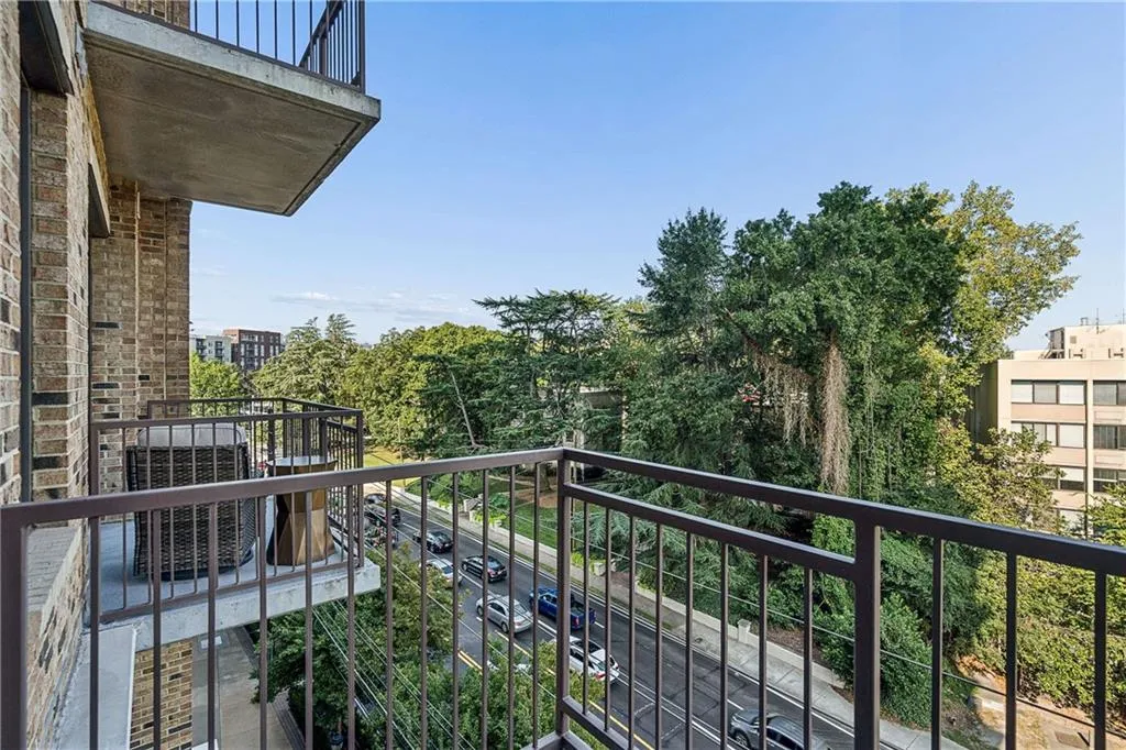 Balcony with metal railing and a brick-finish exterior