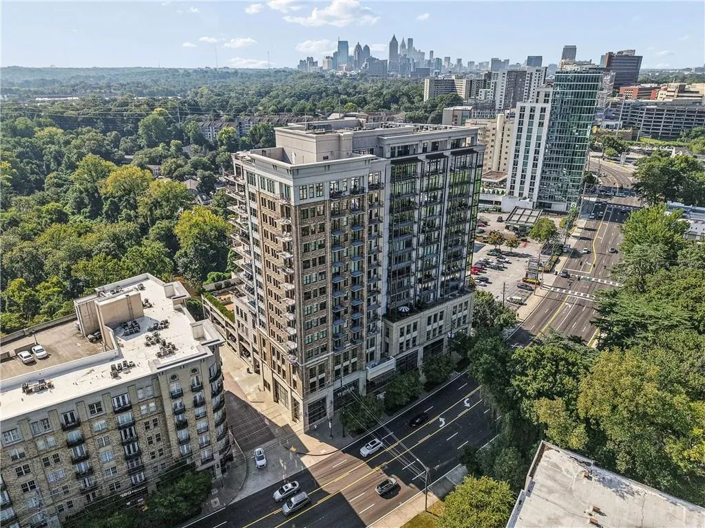 Modern high-rise building featuring multiple balconies, street-level access, and a dense urban setting