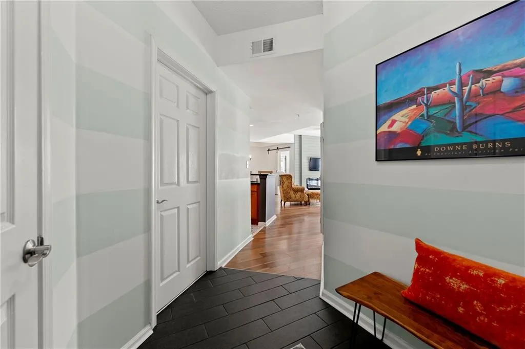 Hallway with visible vents and wood finish floors