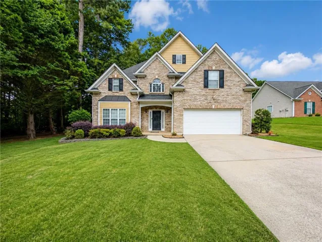 Brick Colonial exterior featuring a two-story design with peaked roofline, multi-pane windows, and a covered entry portico