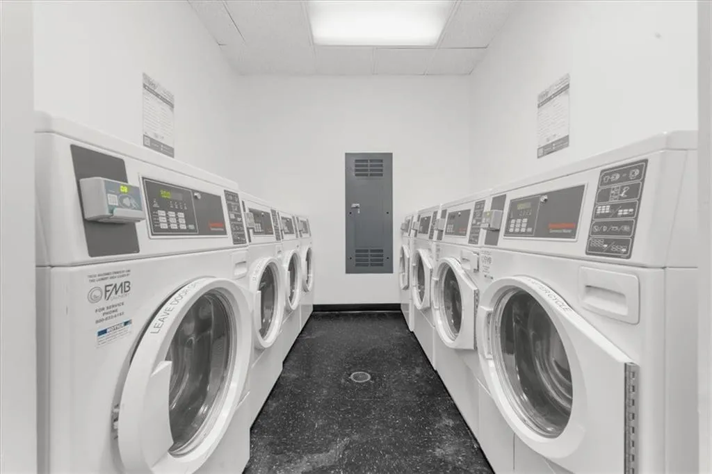 Community laundry featuring electric panel and separate washer and dryer