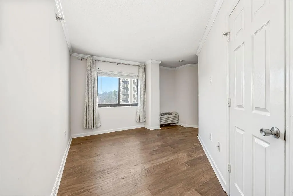 Unfurnished bedroom featuring ornamental molding and wood finished floors