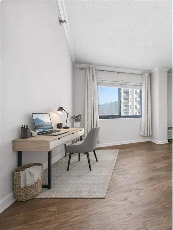 Office area featuring wood finished floors, ornamental molding, and a textured ceiling