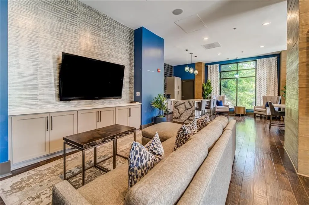 Living area with a chandelier, dark wood-style flooring, and recessed lighting