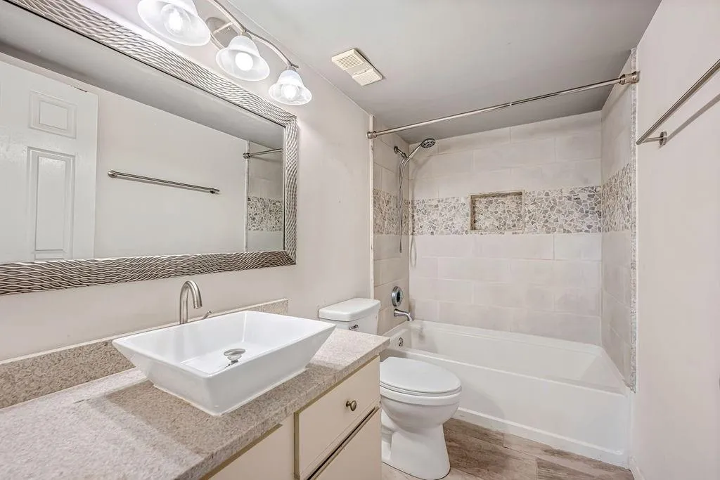 Full bath with shower / tub combination, vanity, and light wood-type flooring