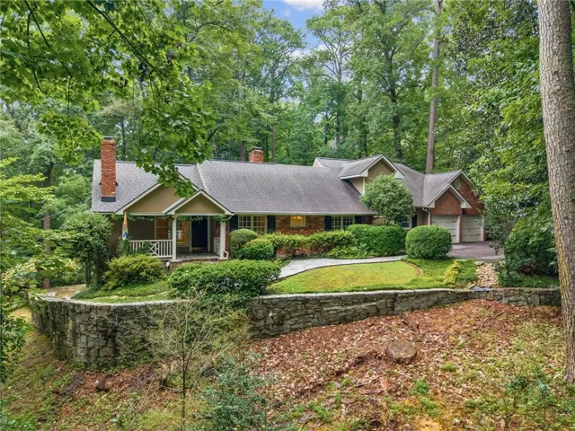 Traditional home with a covered front porch, brick chimney, and attached two-car garage