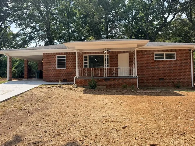 Brick exterior with a covered carport, covered front porch, and white porch railings