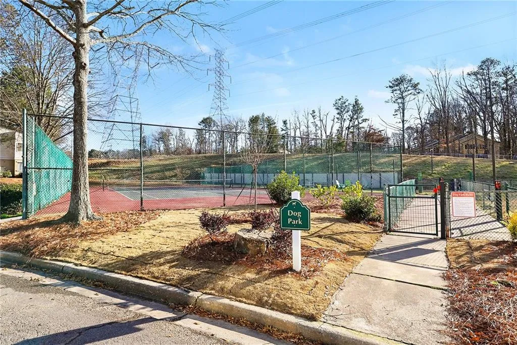 View of tennis court with a gate