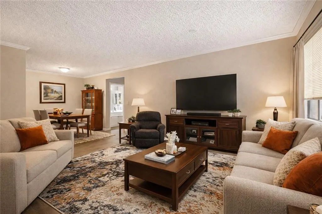Living area with ornamental molding and a textured ceiling