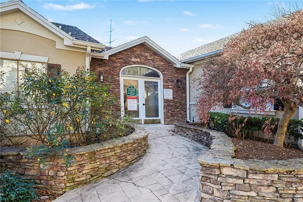 Entrance to property with stone siding, stucco siding, french doors, and a patio area