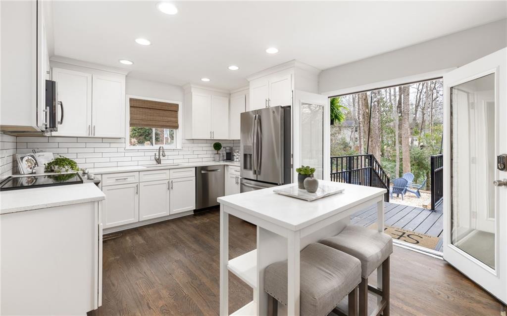 The kitchen is a chef's delight, featuring sleek granite countertops, stainless steel appliances, custom cabinetry, pantry, adjoining dining room and views to the family room.
