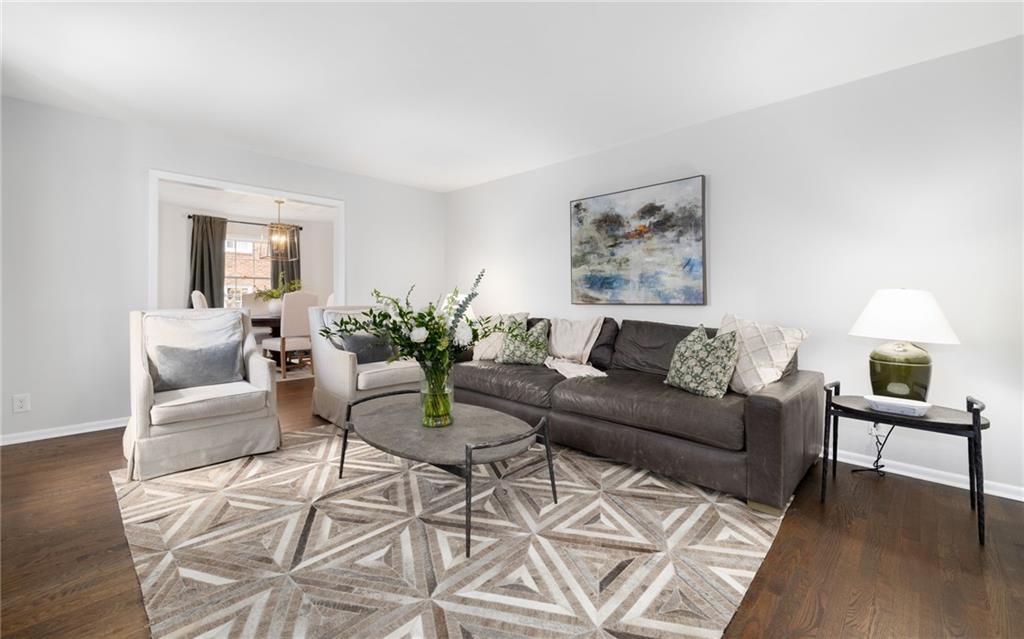 The main level welcomes you with an inviting formal living space, adorned with hardwood floors, crown molding, and ample natural light pouring in through the many windows.