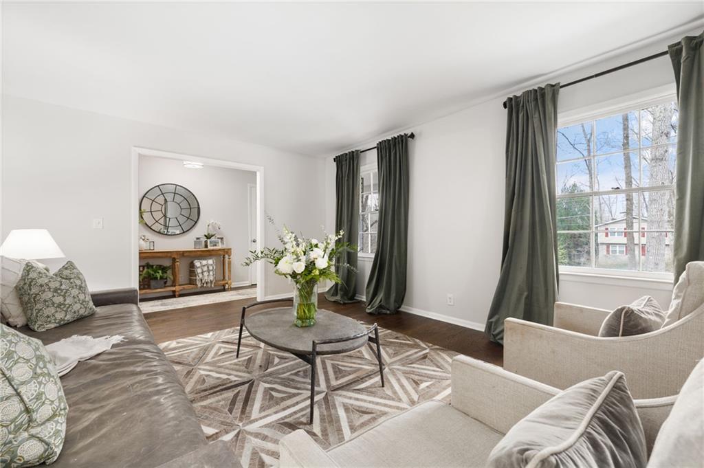 The main level welcomes you with an inviting formal living space, adorned with hardwood floors, crown molding, and ample natural light pouring in through the many windows.