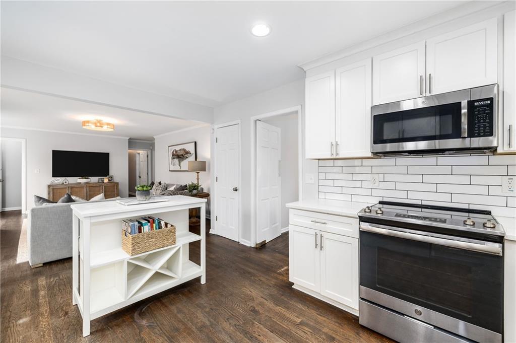 The kitchen is a chef's delight, featuring sleek granite countertops, stainless steel appliances, custom cabinetry, pantry, adjoining dining room and views to the family room.