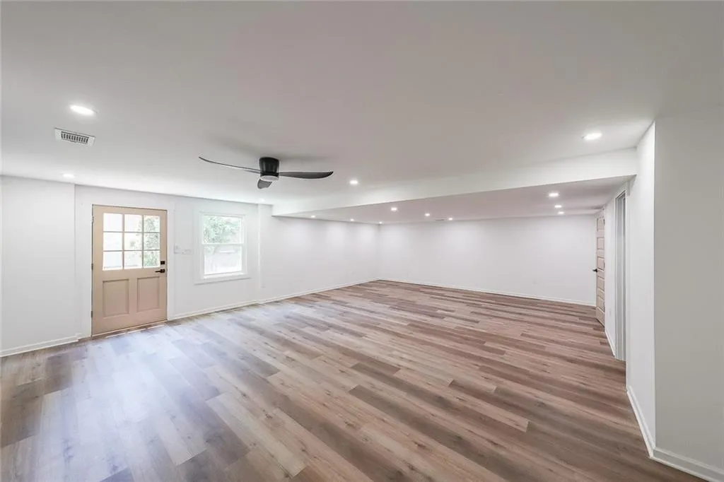 Basement featuring light hardwood / wood-style floors and ceiling fan