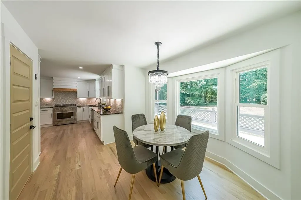 Dining space featuring a healthy amount of sunlight, sink, light wood-type flooring, and an inviting chandelier