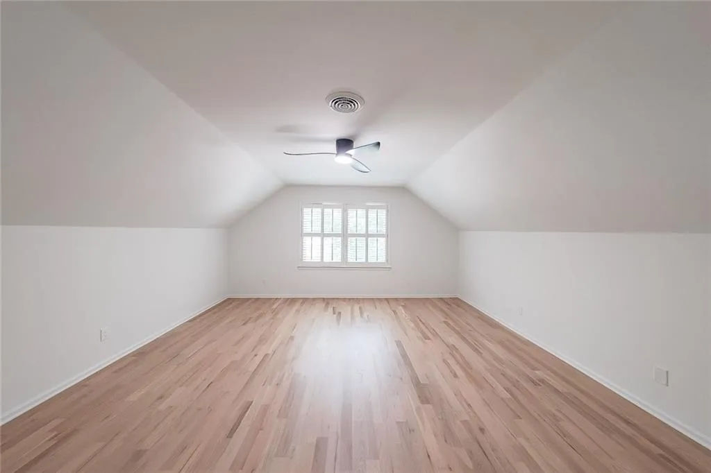 Bonus room/ Bedroom with vaulted ceiling, ceiling fan, and light wood-type flooring