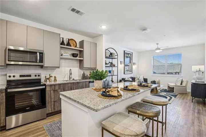 Kitchen featuring a kitchen island, stainless steel appliances, ceiling fan, light wood-type flooring, and sink
