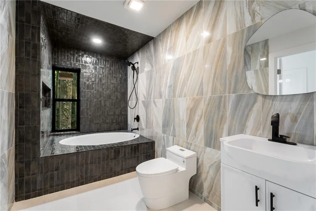 Upper level bathroom with oversized heated soaker tub, quartz tile and Kohler fixtures.