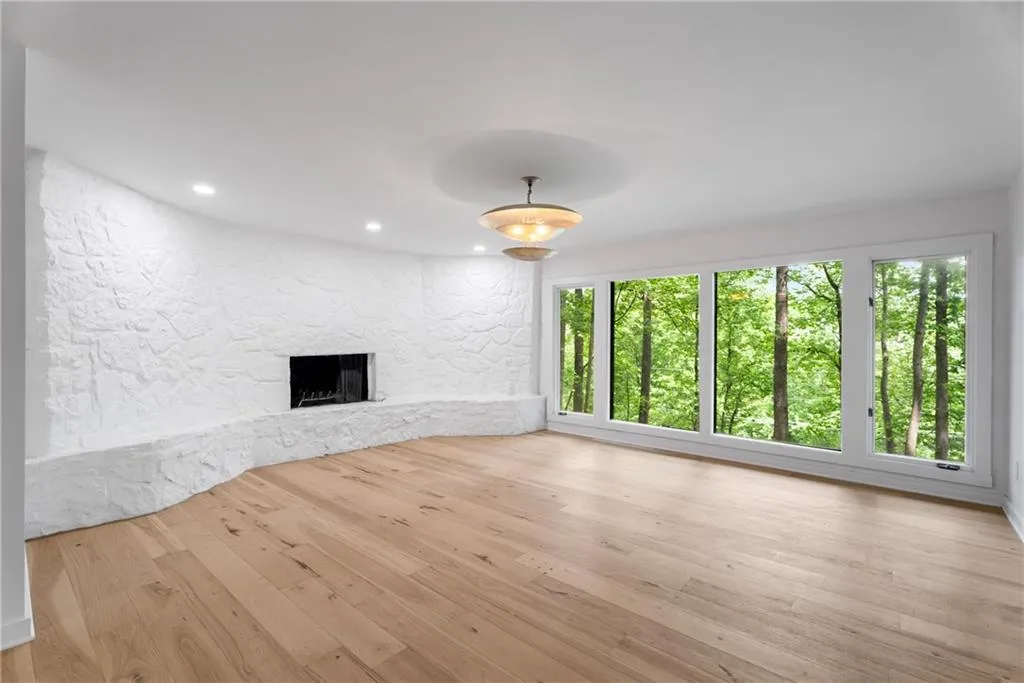 Wood burning fireplace anchoring this light drenched room. This space is ideal as a living or dinning space.