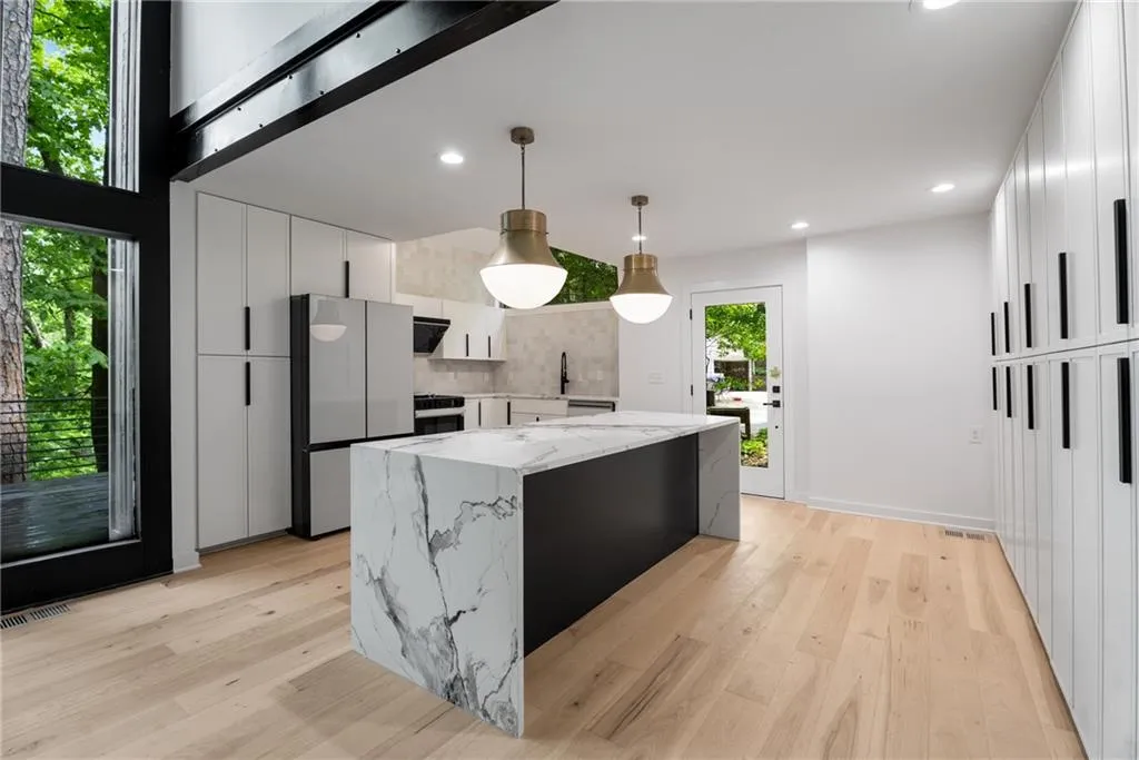 Chefs kitchen with large island, quartz countertops, ample cabinetry and smart appliances.