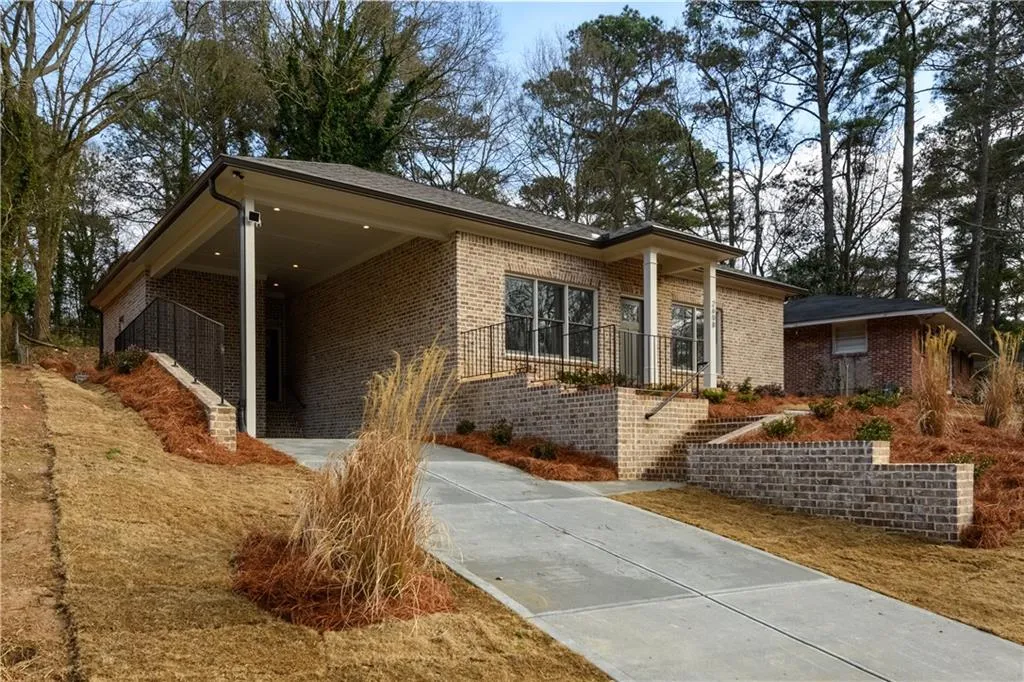Single story home with driveway, a carport, and brick siding