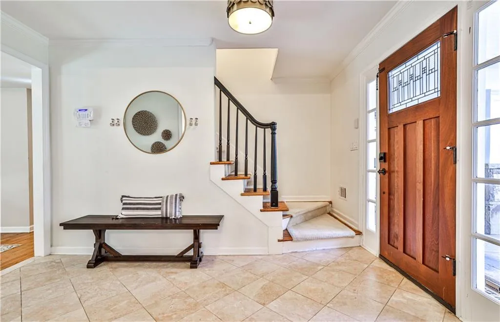 Tiled foyer featuring ornamental molding