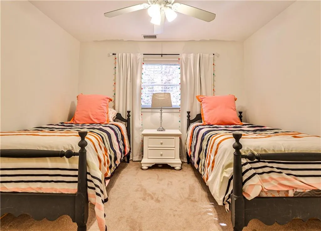 Bedroom with ceiling fan and light colored carpet