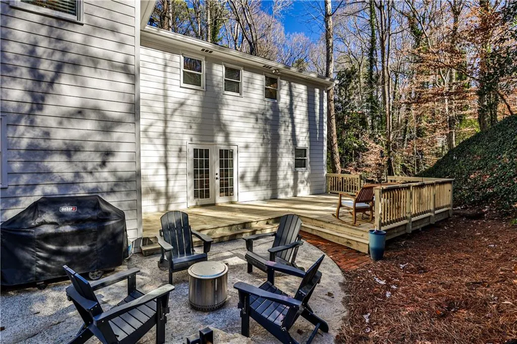 Back of house featuring a deck, french doors, and an outdoor fire pit