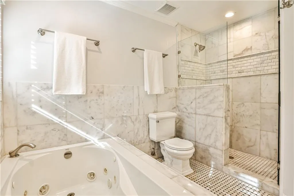 Bathroom with shower with separate bathtub, ornamental molding, tile walls, and toilet