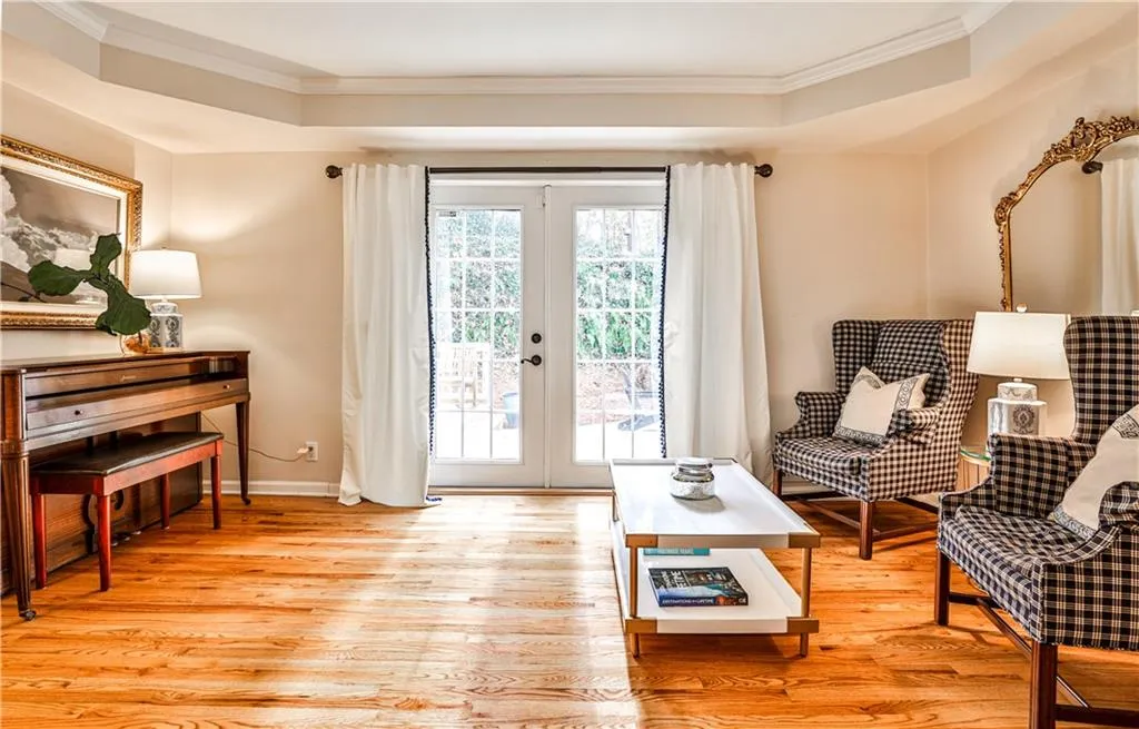 Sitting room featuring light hardwood / wood-style flooring, ornamental molding, and french doors
