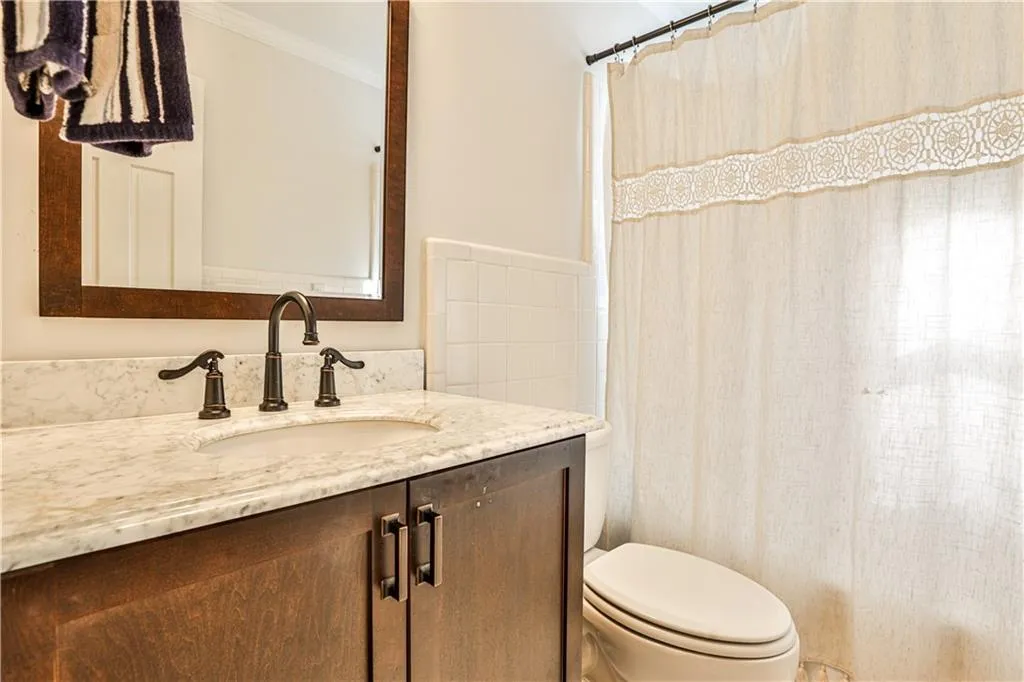 Bathroom featuring vanity, ornamental molding, toilet, and a shower with shower curtain