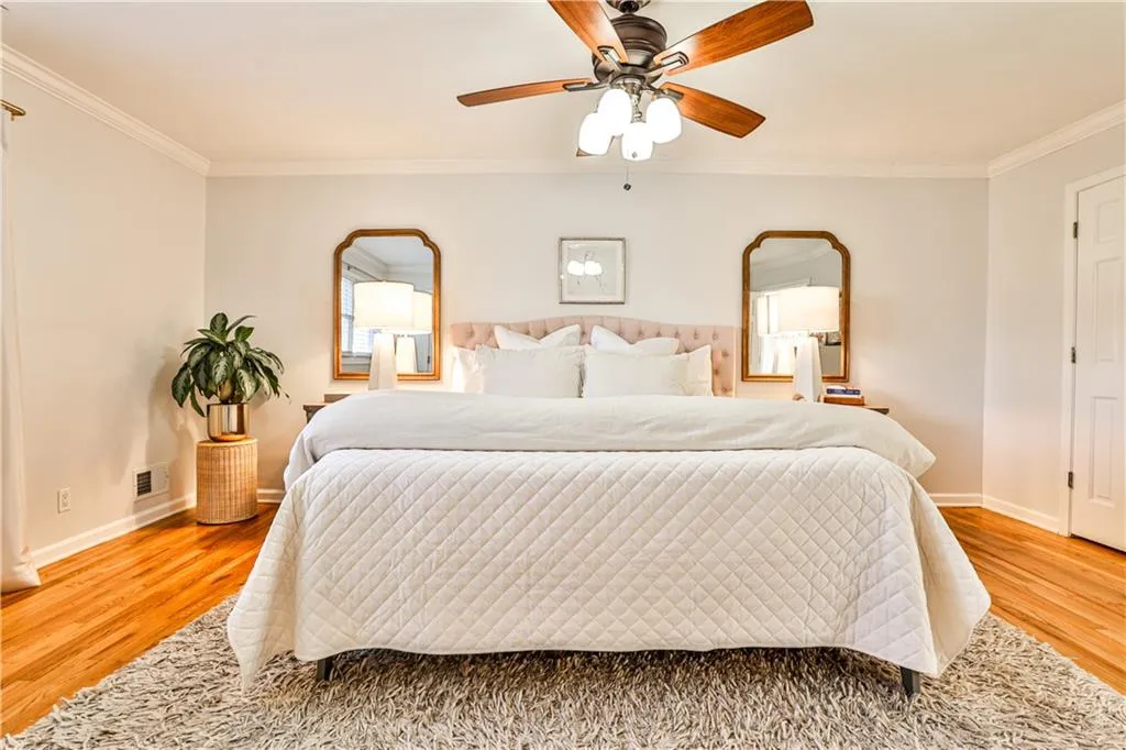 Bedroom with crown molding, ceiling fan, and wood-type flooring