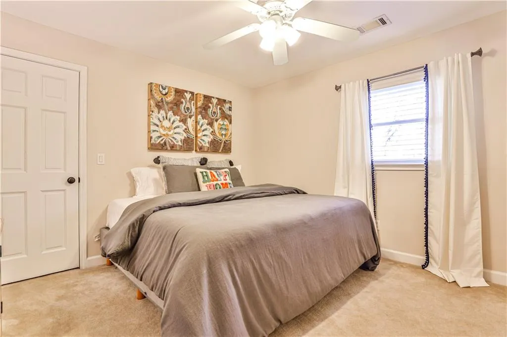 Bedroom featuring light colored carpet and ceiling fan
