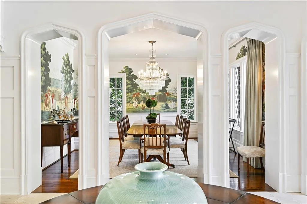 Dining room featuring hand painted de Gournay wallpaper,  chandelier, crown molding, wood finished floors.