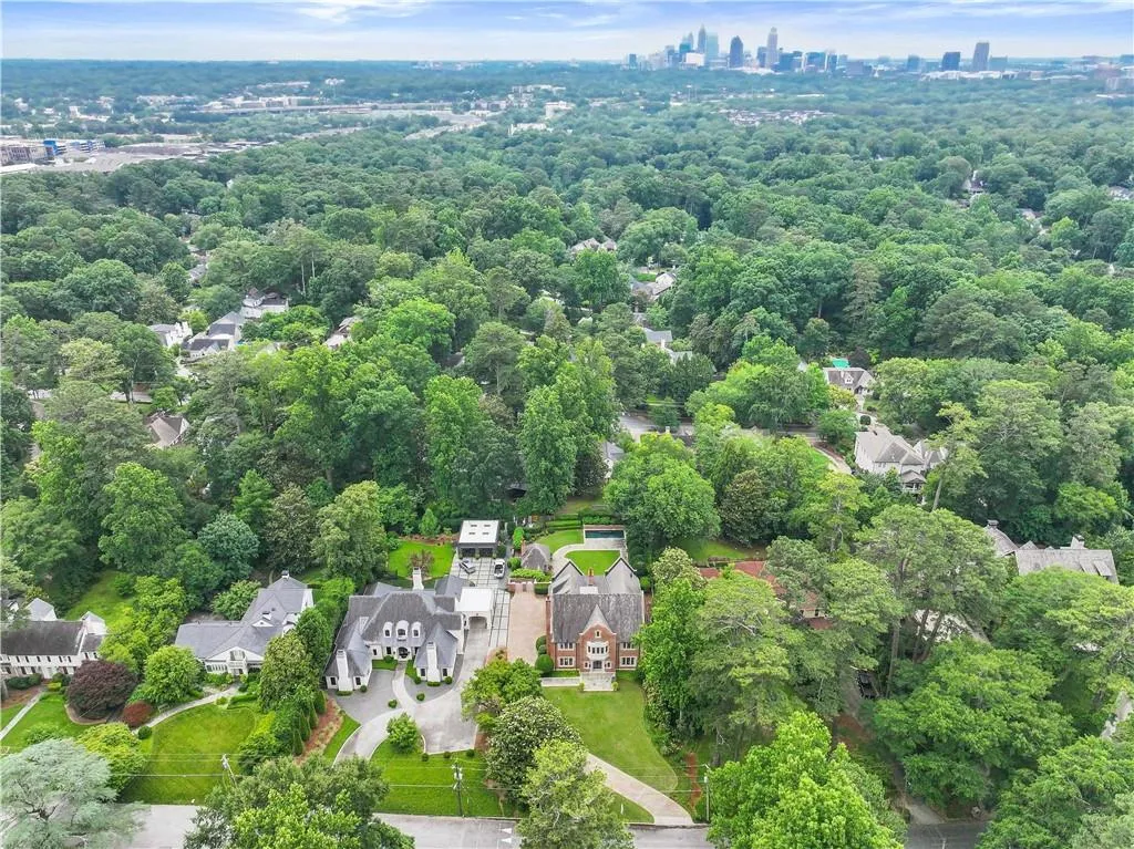 Expansive property featuring a mature treed landscape, a paved driveway, and manicured lawns