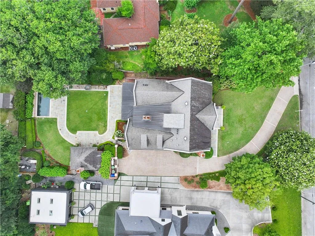Expansive property featuring a large residence with a multi-pitched roof, a rectangular swimming pool, and a manicured lawn