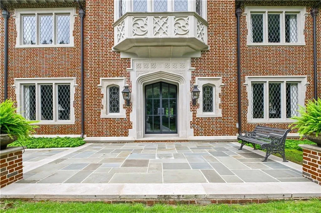 Brick facade featuring a carved stone entryway and decorative balcony