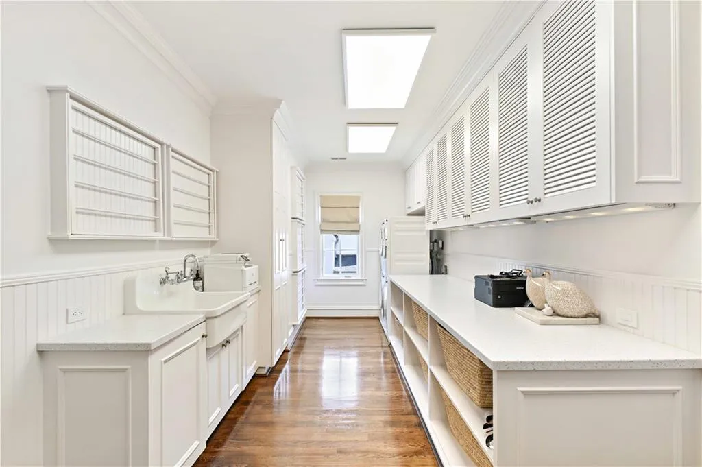 Laundry Room featuring new double washers & Dryers, deep sink and ample cabinetry
