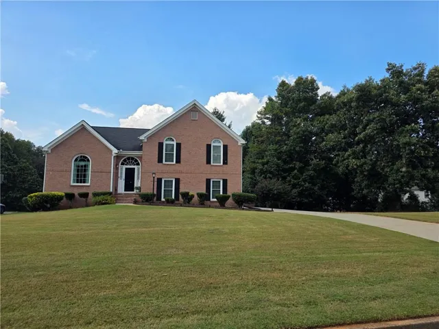 View of front of property featuring a front yard and brick siding