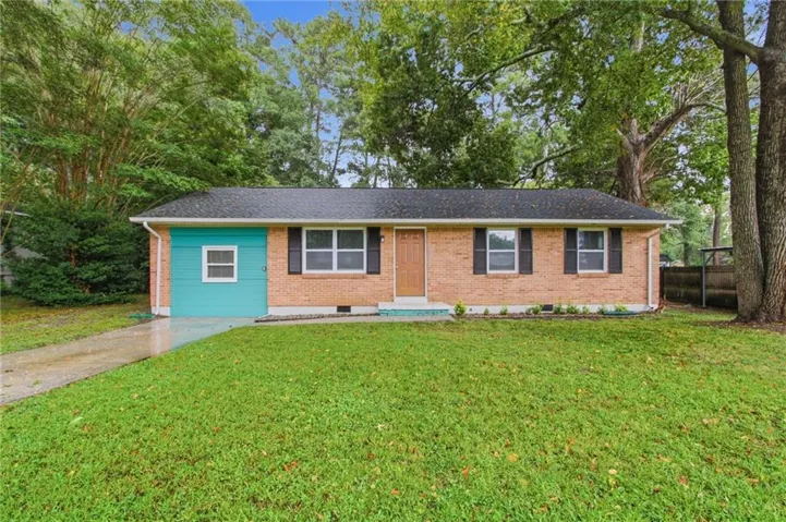 Brick exterior with vibrant accent siding, black window shutters, and a well-maintained front lawn
