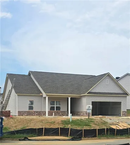 Single-story residence featuring light gray siding, a dark shingle roof, and brick detailing