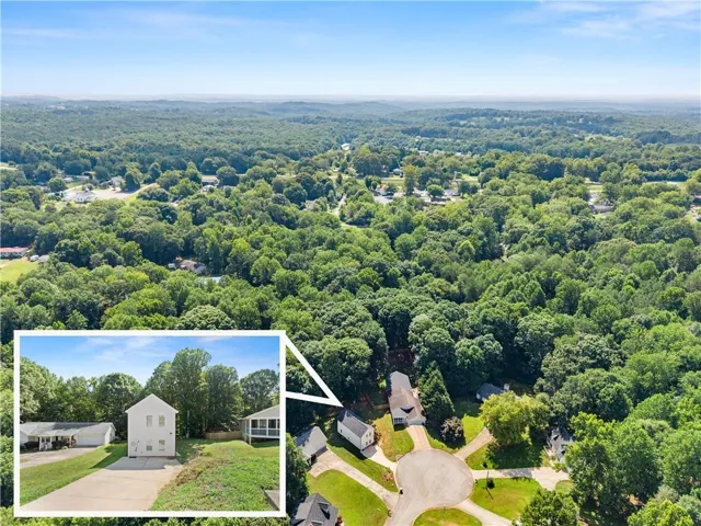 Aerial perspective showcasing the property within a verdant, tree-filled landscape