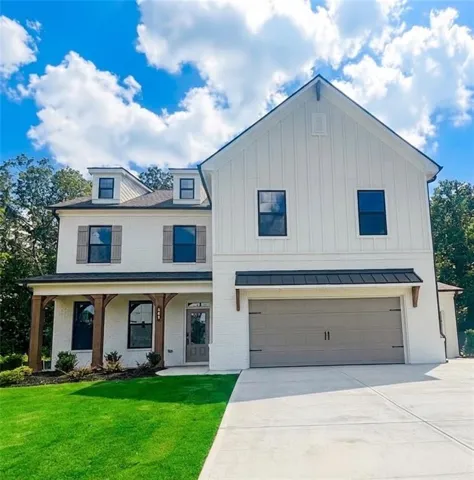 Two-story residence featuring a white brick and board-and-batten exterior