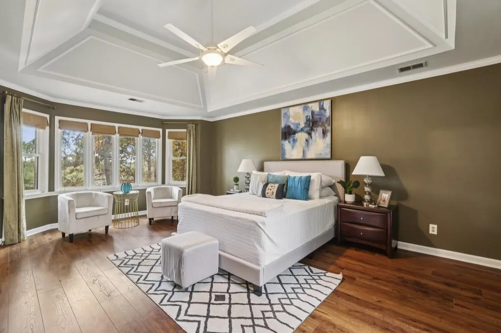 The Luxurious Primary Suite, showcasing Tray Ceilings and A Private Sitting Room, perfect as a Nursery, Additional Closet, Or Home Office