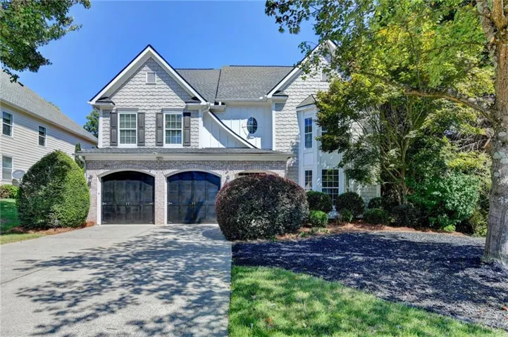 Traditional-style exterior with shingle siding and brick accents